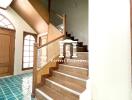 Staircase in a home with green tiled floor and wooden steps