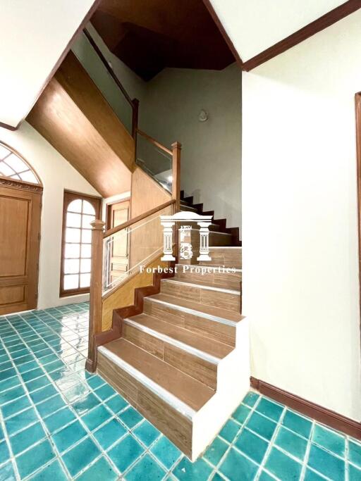 Staircase in a home with green tiled floor and wooden steps