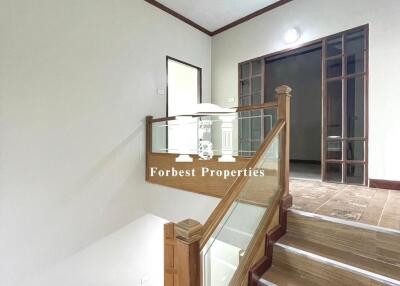 Staircase with wooden railing and glass panels in a modern interior