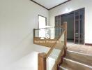 Staircase with wooden railing and glass panels in a modern interior