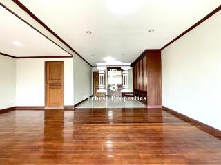 spacious empty room with wooden flooring and wooden accents on ceiling and doors