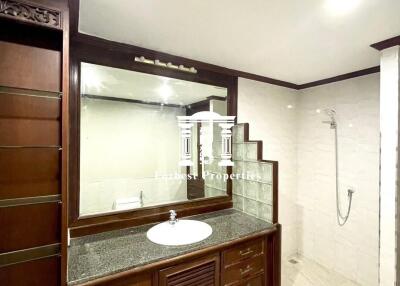 Modern bathroom with wooden cabinets and walk-in shower