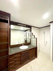 Modern bathroom with wooden cabinets and walk-in shower