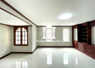 Spacious living room with large windows and built-in wooden shelves