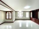 Spacious living room with large windows and built-in wooden shelves