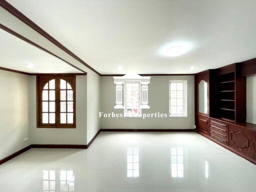 Spacious living room with large windows and built-in wooden shelves