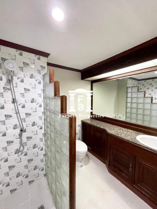 Bathroom with modern fixtures and wooden cabinetry