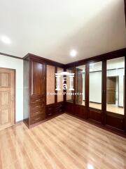 Bedroom with built-in wooden wardrobes and wooden flooring