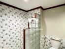 Bathroom with tiled walls and glass block divider