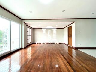 Spacious living room with hardwood flooring and large windows