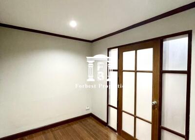 Empty bedroom with wooden floor and sliding wooden door