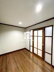 Empty bedroom with wooden floor and sliding wooden door