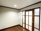 Empty bedroom with wooden floor and sliding wooden door