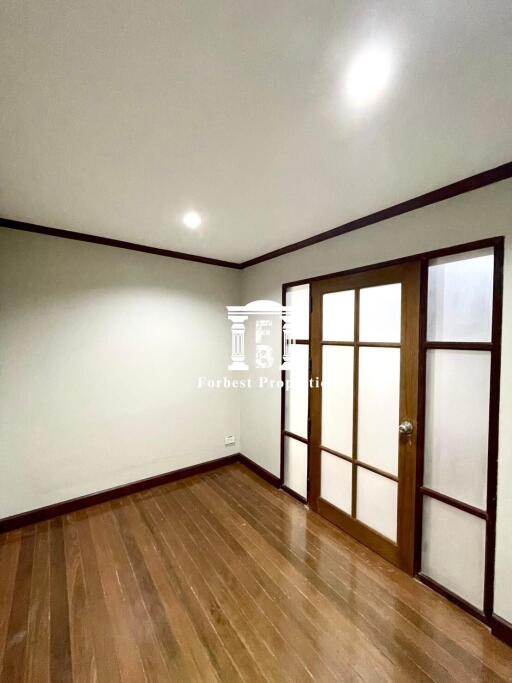 Empty bedroom with wooden floor and sliding wooden door