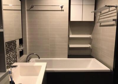 Modern bathroom with sink, bathtub, and shelving
