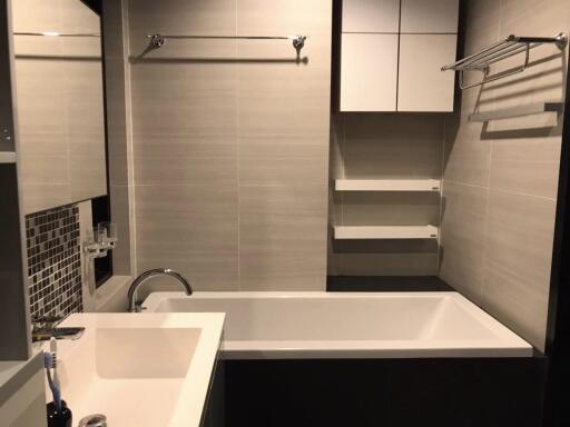 Modern bathroom with sink, bathtub, and shelving