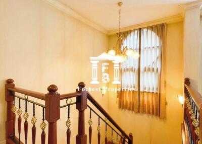 Staircase with wooden rails and chandelier