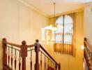 Staircase with wooden rails and chandelier