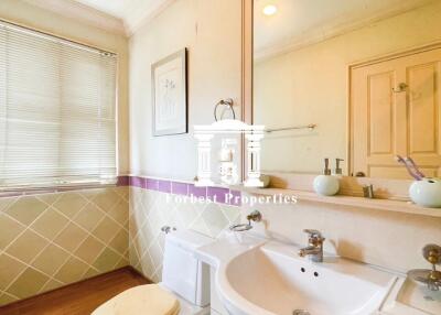 Well-lit bathroom with sink, toilet, and window