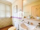 Well-lit bathroom with sink, toilet, and window