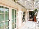 Open balcony area with glass doors and a pergola