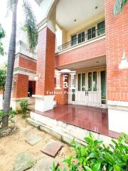 Bright and welcoming entrance of a residential building with red brick and white trims