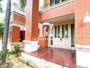 Bright and welcoming entrance of a residential building with red brick and white trims