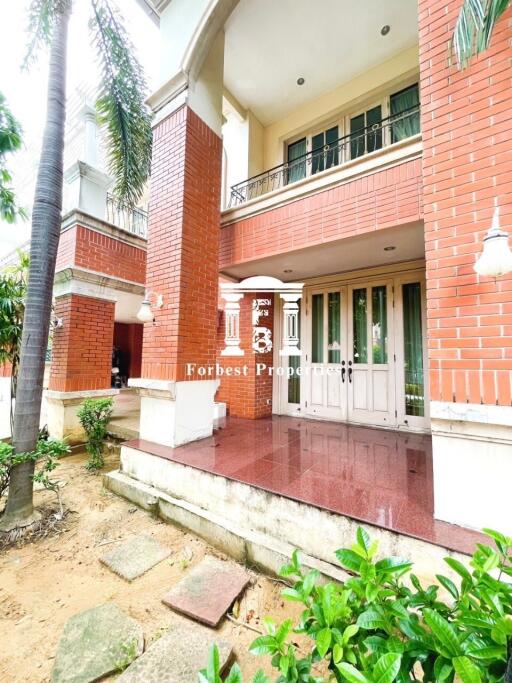 Bright and welcoming entrance of a residential building with red brick and white trims