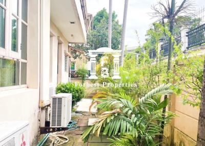 Outdoor walkway with greenery and air conditioning units