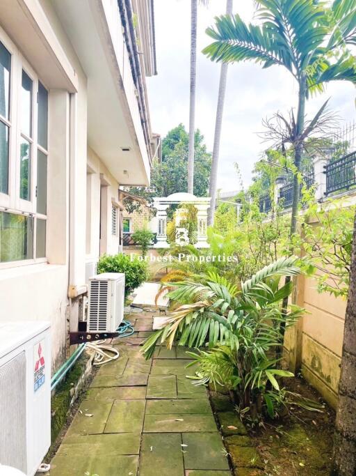 Outdoor walkway with greenery and air conditioning units