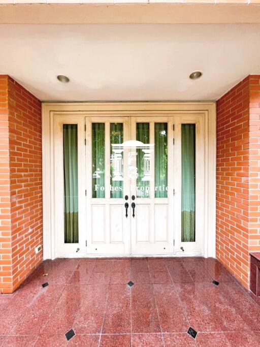 Front entrance with double doors and brick walls