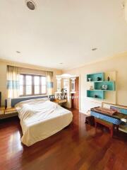 Spacious bedroom with wooden flooring and large window