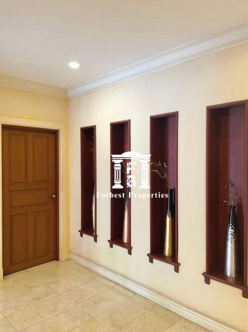 Hallway with decorative wall niches and a wooden door