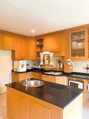 Modern kitchen with wooden cabinetry and black countertops