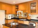 Modern kitchen with wooden cabinetry and black countertops