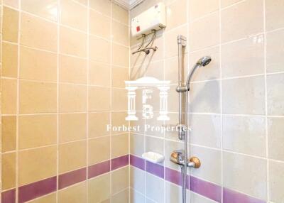 Shower area with tiled walls and built-in shelf