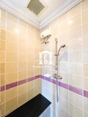 Shower area with tiled walls and built-in shelf