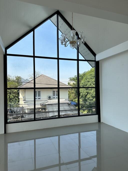 Living area with large triangular window and chandelier