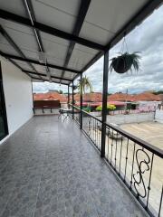 Spacious balcony with metal railing and outdoor seating