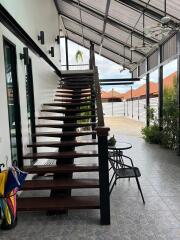 Covered outdoor stairs with seating area and hanging plants