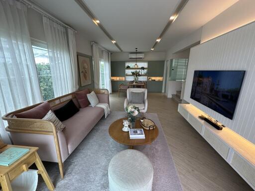 Modern living room with a large window, comfortable seating, and a TV