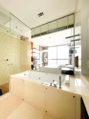 Modern bathroom with jacuzzi and view of living area