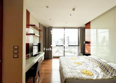 Spacious bedroom with a large window offering a city view