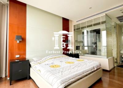 Modern bedroom with wooden flooring and glass wall