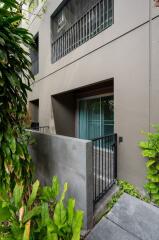 Outdoor view of a multi-story residential building with plants