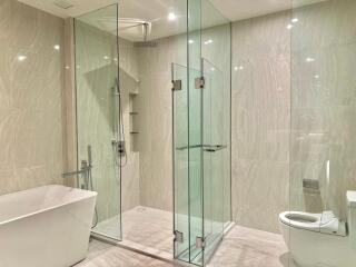 Modern bathroom with glass shower enclosure and freestanding bathtub