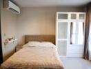 Modern bedroom with bed, wardrobe, and air conditioning