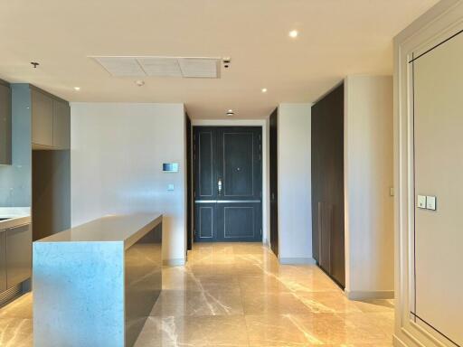 Modern kitchen area with built-in appliances and marble countertop