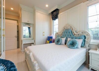 luxurious bedroom with elegant white furniture and blue accents