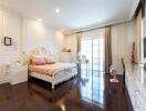 Spacious elegant bedroom with large bed, hardwood floors, and large windows